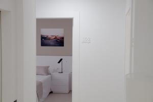 een witte kamer met een bed en een bank bij Sosiego Hostal de Mar in Puerto de Mazarrón