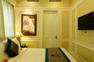 a hotel room with a bed and a flat screen tv at Anpha Boutique Hotel in Ho Chi Minh City