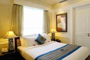 a hotel room with a large bed with a window at Anpha Boutique Hotel in Ho Chi Minh City