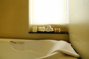 a white bath tub in a bathroom with a window at Anpha Boutique Hotel in Ho Chi Minh City