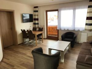 a living room with a couch and a table and chairs at Haus Marjanne in Niederau