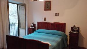 a bedroom with a bed and a large window at B&B ERMINIA in Laino Borgo