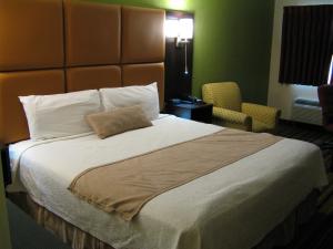 a hotel room with a large bed and a chair at Inn at Portland in Portland