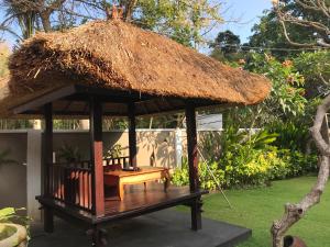 a small gazebo with a thatch roof at The Celuk Homestay in Jimbaran
