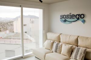 Sosiego Hostal de Mar في بويرتو دي مازارون: أريكة بيضاء في غرفة مع نافذة كبيرة