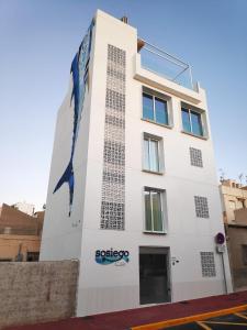 un edificio blanco con un cartel en el costado en Sosiego Hostal de Mar, en Puerto de Mazarrón