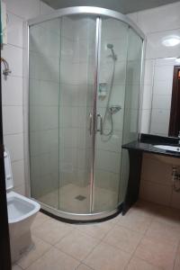 um chuveiro com porta de vidro em um banheiro em Excelsior Resort em Dili