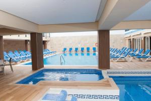 piscina con sedie blu e piscina di Euroclub Hotel a San Pawl il-Baħar