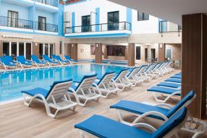 una piscina con sedie a sdraio e una piscina di Euroclub Hotel a San Pawl il-Baħar