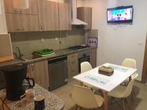 a kitchen with a table and a sink and a tv at Luxe et spacieux au Jardin de Carthage in Sidi Daoud
