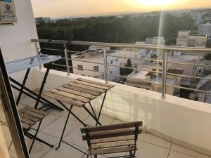 Sidi Daoud的住宿－Luxe et spacieux au Jardin de Carthage，美景阳台,配有两把椅子和一张桌子