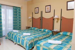 - une chambre d'hôtel avec 2 lits et des serviettes dans l'établissement Euroclub Hotel, à San Pawl il-Baħar