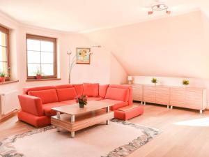 uma sala de estar com sofás vermelhos e uma mesa de centro em VacationClub – Osiedle Podgórze 1C Apartament 22 em Szklarska Poręba