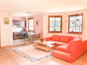 a living room with a red couch and a table at VacationClub – Osiedle Podgórze 1C Apartament 22 in Szklarska Poręba