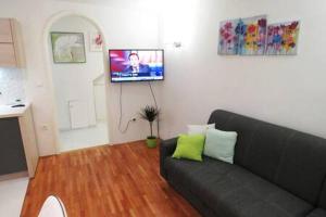 a living room with a couch and a flat screen tv at Apartman Luna in Šibenik