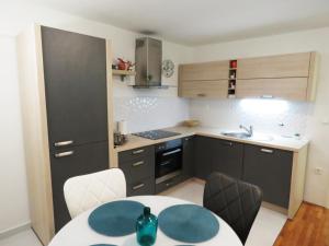 a kitchen with a table and some chairs and a sink at Apartman Luna in Šibenik