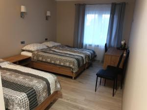 1 dormitorio con 2 camas, mesa y silla en motel na stacji paliw en Ustronie Morskie