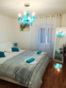 - une chambre avec un grand lit et un lustre dans l'établissement Apartman Luna, à Šibenik