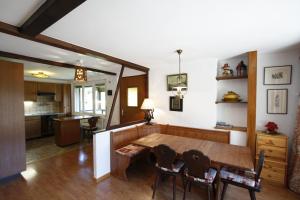 クランにあるApartment Villa Francaのキッチン、ダイニングルーム(木製のテーブルと椅子付)