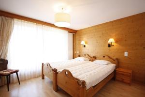 クランにあるApartment Villa Francaの木製の壁のベッドルーム1室(大型ベッド1台付)