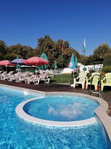 a large swimming pool with chairs and umbrellas at Detelina Complex in Hisarya
