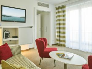 ein Wohnzimmer mit einem Sofa und einem Tisch in der Unterkunft Werzers Hotel Resort Pörtschach in Pörtschach am Wörthersee