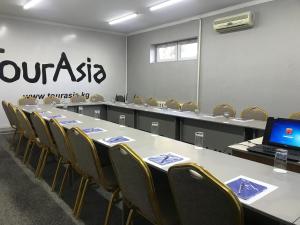 a conference room with a table and chairs and a laptop at TourAsia Hotel in Bishkek