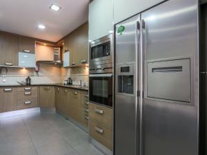 a kitchen with stainless steel appliances and wooden cabinets at V3, Villa Jardins Branqueira6 near Beach, Albufeira in Albufeira