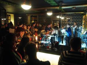 un groupe de personnes assises dans un bar dans l'établissement Rolling Stones hostel, à Irkoutsk
