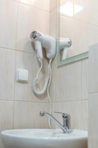 a hairdryer hanging on a wall above a sink at AirPark Balice in Balice