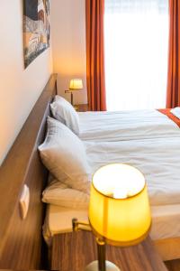 a hotel room with a bed and a yellow lamp at AirPark Balice in Balice