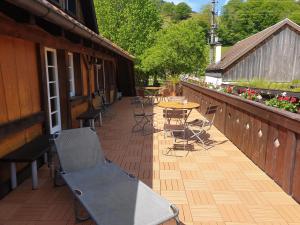 eine Terrasse mit Tischen und Stühlen auf einer Holzterrasse in der Unterkunft Gasthaus Hirtenbrunnen in Hof