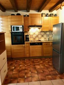 eine Küche mit Küchengeräten aus Edelstahl und Holzschränken in der Unterkunft Gite chez Annette et Pierre Weber in Niedernai