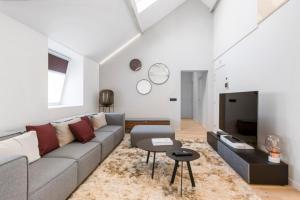 a living room with a couch and a tv at Design Loft near the city of Ghent in Ghent