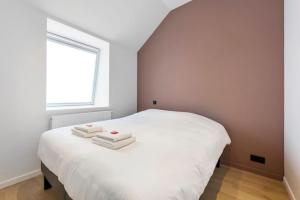 a bedroom with a white bed with two towels on it at Design Loft near the city of Ghent in Ghent