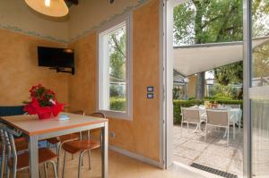 una sala da pranzo con tavolo e patio di Park Gallanti a Lido di Pomposa