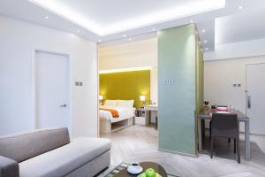 a living room with a couch and a room with a bed at Eaton Residences, Village Road in Hong Kong