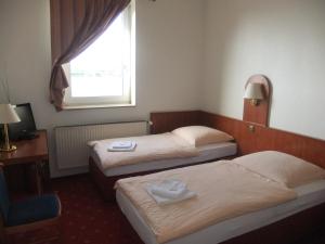 ein Hotelzimmer mit 2 Betten und einem Fenster in der Unterkunft Hotel Adriatic in Hannover