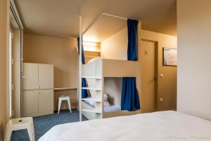 a small bedroom with a bunk bed and blue curtains at The People - Tours in Tours