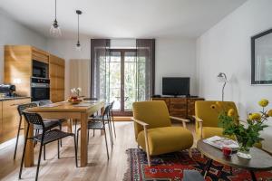 a kitchen and living room with a table and chairs at Sanhaus Apartments - Apartament Grand z balkonem i parkingiem in Sopot