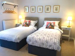 dos camas sentadas una al lado de la otra en un dormitorio en The View Cottage - Tennis Court - Nr Frome, Longleat, en Frome