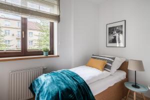 a small bedroom with a bed and a window at Sanhaus Apartments - Apartament Grand z balkonem i parkingiem in Sopot