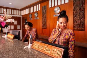 two women sitting at a counter talking on a cell phone at Baumancasa Beach Resort in Karon Beach