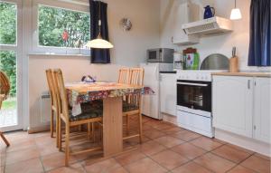 a kitchen with a table and chairs and a kitchen with white appliances at Awesome Home In Grindsted With Kitchen in Grindsted +8 photos