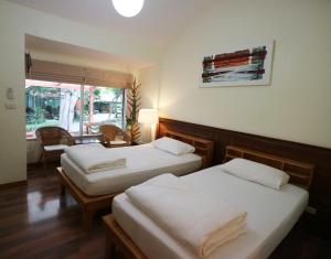 a hotel room with two beds and a window at Palita Lodge - SHA Plus in Haad Rin