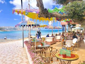 a cafe on the beach with tables and umbrellas at Apartamento Benvinguts I in Jávea