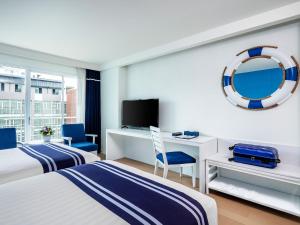 a hotel room with two beds and a tv at A-One New Wing Hotel in Pattaya