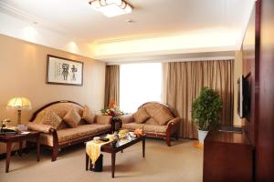 a living room with two couches and a tv at Changchun Huatian Hotel in Changchun +2 photos