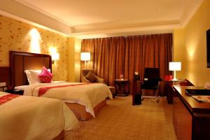 a hotel room with two beds and a desk at Changchun Huatian Hotel in Changchun