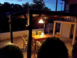 卡蘭巴卡的住宿－Proias Guesthouse 7km from Meteora!At village VLACHAVA，凉亭下的木桌和椅子